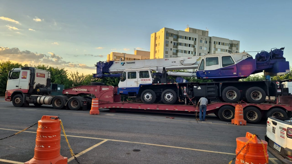 Prancha da Mtech Premoldados transportando guindaste para o canteiro de obras, garantindo eficiência e segurança na logística.